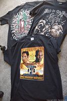 Photo showing all three graphic t-shirts laid on floor, visible front designs