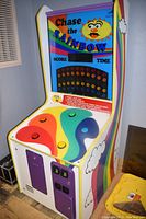 Right-front angled view of the Chase the Rainbow arcade game showing the colorful buttons and side rainbow design.