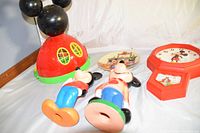 Photo showing Mickey Mouse house bank, two figurines, 1986 Mistletoe Magic plate, and Mickey Mouse clock.