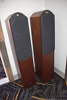 Both speakers upright with fabric grilles installed on front faces