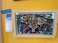 Full view of framed painting by Broderson mounted on yellow wall