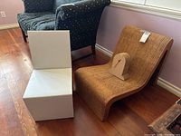 Wide view showing white folding chair, corrugated lounge chair, and small cardboard clock on lounge chair