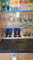 Various colored and styled glassware displayed on shelves