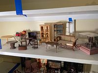 Full spread of miniature dollhouse living room furniture including tables, chairs, sofas, cabinets.