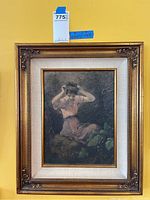 Front view of framed signed artwork showing a woman in pink dress sitting outdoors with a floral crown.