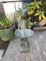 Front view of cat statue holding bird bath dish on rectangular base