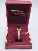 Full view of the watch inside the open red case showing branding and watch presentation.