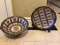 Two China bowls: one displayed on stand showing interior pattern, other lying flat