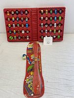 Full open view of the carrying case with 52 Mighty Beanz inside, plus the red Trick Track launcher tool in original packaging next to the case.