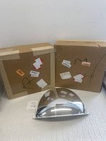 Three corner ceiling reflective mirrors shown with two in boxes and one out of box, facing reflective side up.