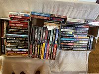 Three boxes of James Patterson books shown from above, displaying spines of many titles in paperbacks and hardcovers.