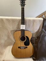 Full front view of Alcivar guitar showing dreadnought body, black pickguard and tuning pegs.