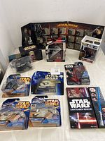 Overview of 10 Star Wars collectibles including pins, figures, die-cast vehicles, and book.