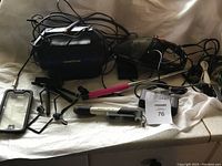 Photo showing Goodyear air compressor, portable car vacuum, spy cameras, cables and accessories laid out on a surface.