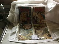 Four vintage comic books arranged on a table including Bob Hope and Classics Illustrated titles.