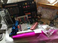 Overview of assorted craft supplies including an art set with crayons, colored pencils, paint, pens, glitter, and a craft kit with LED molds.