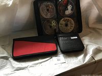 Photo of three DVD storage cases with DVDs inside, showing various DVD discs with artwork visible.