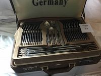 Open case showing top tray with forks, knives and teaspoons in fitted slots
