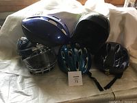 Full lot display of five helmets showing different types and condition.