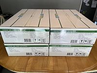 Four sealed boxes labeled 1000W DE CMH System by Lumagro on a wood table.
