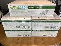 Boxed Lumagro LG-205 commercial grow lights showing model name and system specifications (1000W DE CMH).
