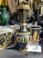 Front and side view of the black ceramic vase decorated with ancient Greek mythological figures and gold key patterns.
