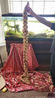 Full length image showing the macrame plant holder held up to demonstrate size approximately 80 inches.