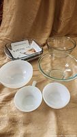 Entire set of six mixed vintage ovenproof glassware items including clear and white bowls and a rectangular dish.