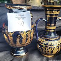Two Neofitu Greek decorative vases in black with gold classical figure and floral decorations, placed side by side
