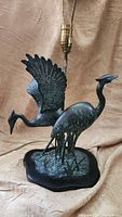 Full view of vintage bronze herons lamp showing two birds and lamp fixture.