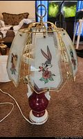 Close-up of lamp showing Bugs Bunny glass panel and brass accents.