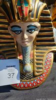 Front view of the vintage Pharaoh bust showing detailed face, blue eye makeup, and colorful headdress with gold and black stripes.