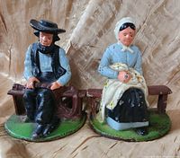 Front view of the Wilton cast iron Amish couple figures, showing painted details and seated poses.