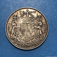 Reverse side of the coin showing crowned shield coat of arms with flags, lions, and maple leaves with denomination '50 cents' and year 1950.