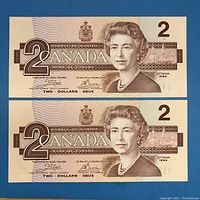 Front sides of the two consecutive 1986 Canadian $2 bills showing the Queen Elizabeth II portrait and serial numbers.