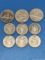 Nine Canadian nickel coins of various dates including one dollar and half dollar denominations. Details of coin faces and dates visible.