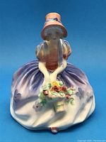 Front view of the Royal Doulton Monica figurine showing detailed hand-painted design and flower basket.