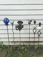 Full view of all six yard ornaments against exterior wall showing layout and condition.