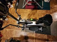 Top view of exercise bike showing cushioned seat, pedals, and handlebar structure.