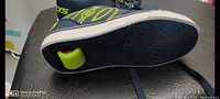 Sole view showing neon yellow wheels and black tread outsole.