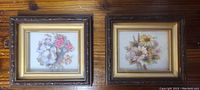 Pair of framed floral prints with wooden distressed frames on wooden surface