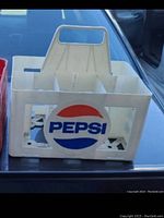 White plastic Pepsi crate with Pepsi logo on the side captured to show the overall condition and detail.