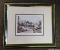 Framed print showing rural countryside scene with house, vintage vehicle, trees, and hills. Frame is dark green with gold trim and has some minor imperfections.