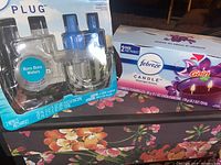 Photo showing Febreze Plug-In refill 2-pack with Bora Bora Waters scent and Gain scented candles 2-pack with double wick