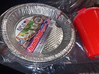Two aluminum pie pans with lids and red plastic jello mold