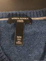 Close-up of Banana Republic label inside the sweater showing size M/M and 100% cashmere material.