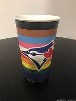 Side view of the ceramic cup showing the Blue Jays logo and pride rainbow colors on the cup exterior.