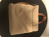 Front view of khaki Joe Fresh tote bag with brown leather handles and trim. Bag appears in good condition with zippered top.