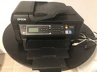 Front angled view of Epson WF-2750 printer showing control panel and paper tray extended