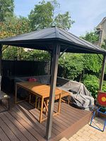 Full exterior view of assembled gazebo on deck, showing roof panels and posts